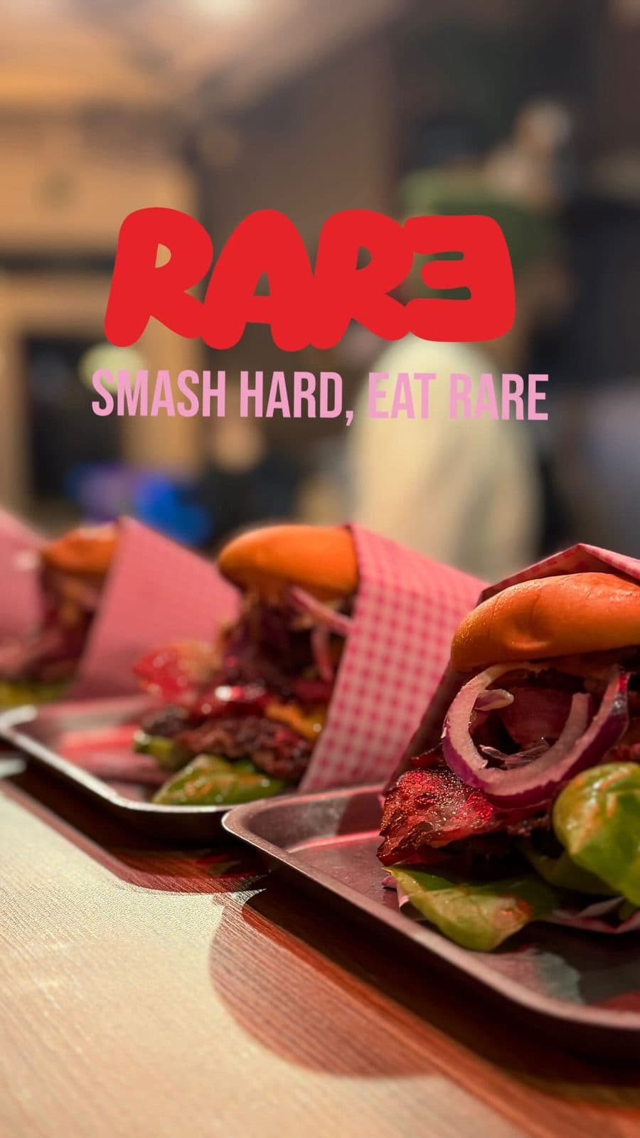 Burgers servis sur des plateaux en métal avec leur papier vichy rose